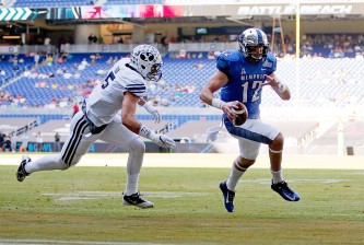 MIAMI, FL - DECEMBER 22:  Paxton Lynch #12 of the Memphis Tigers rushes for a touchdown past defender Alani Fua #5 of the Brigham Young Cougar during the first quarter of the game against the Brigham Young Cougars at Marlins Park on December 22, 2014 in Miami, Florida.  (Photo by Rob Foldy/Getty Images)